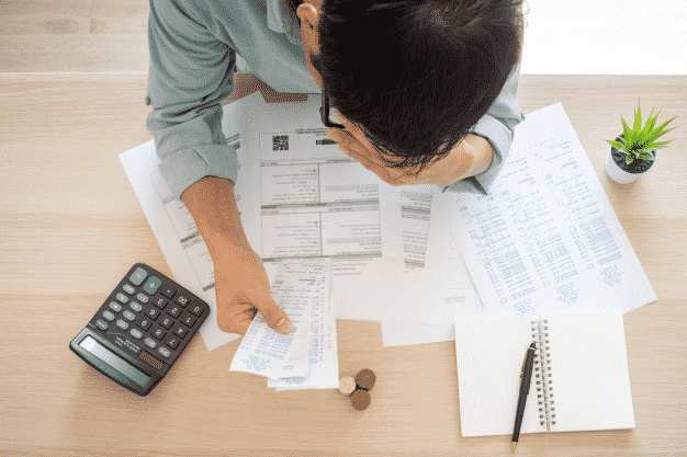 Man Calculating Financials with paperwork and calculator