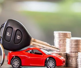 Remote control car and car remote next to coin stack